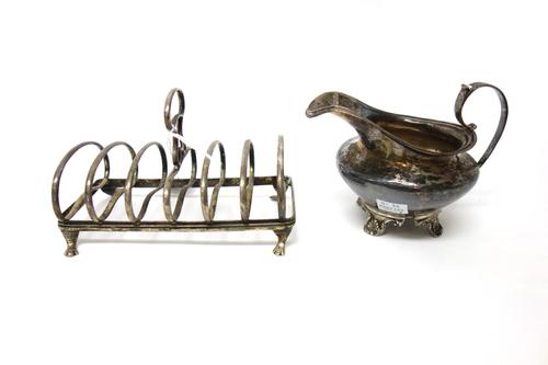 Silver, comprising; a seven bar toastrack, with a loop shaped handle, raised on four paw feet, Chester 1931 and a milk jug, raised on four feet, possi