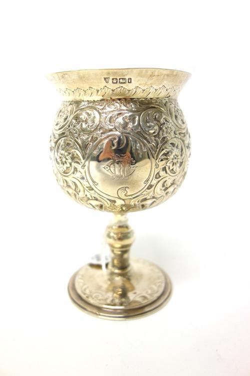 A silver goblet, of globular form, embossed with flowers and scrolls and on a circular foot, height 15cm, Sheffield 1901, weight 257 gms.