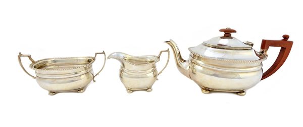 A silver three piece tea set, comprising; a teapot, with composition fittings, a twin handled sugar bowl and a milk jug, each piece of compressed oval