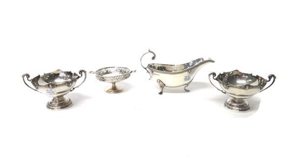 Silver, comprising; two similar twin handled bonbon dishes, decorated with cast borders and raised on circular feet, Birmingham 1954 and 1960, a twin