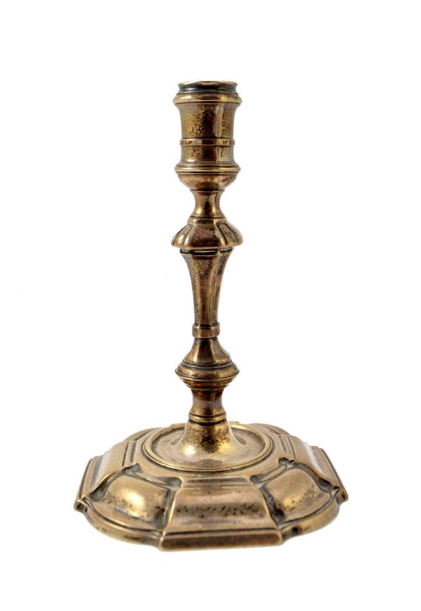 A George II silver taper stick, with a knopped stem raised on a shaped square base, having curved corners, height 10.5cm, weight 105 gms. Illustrated