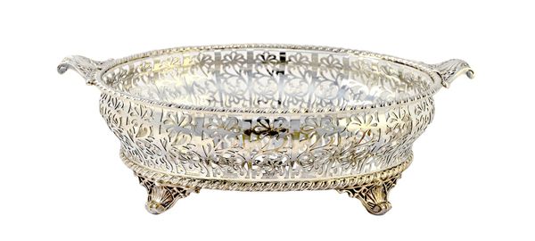 A silver twin handled oval basket, decorated with floral pierced sides within a cable rim, raised on four legs, having scallop motifs, Sheffield 1926,