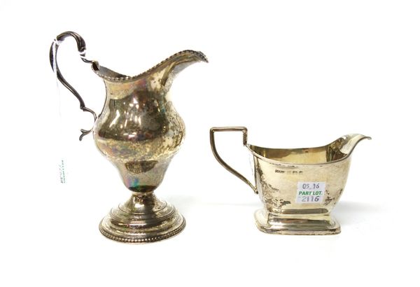 A George III silver cream jug of ogee form, decorated with beaded rims, monogram engraved and with a scrolling handle, London possibly 1767 and a silv