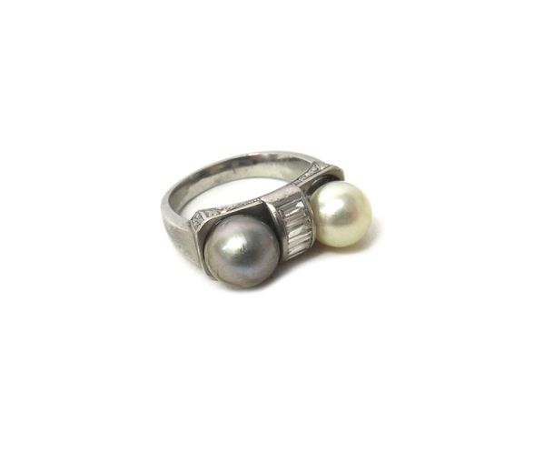 A 20th century white metal mounted ring set with one grey and one white cultured pearl, separated by a row of six baguette cut diamonds, gross weight