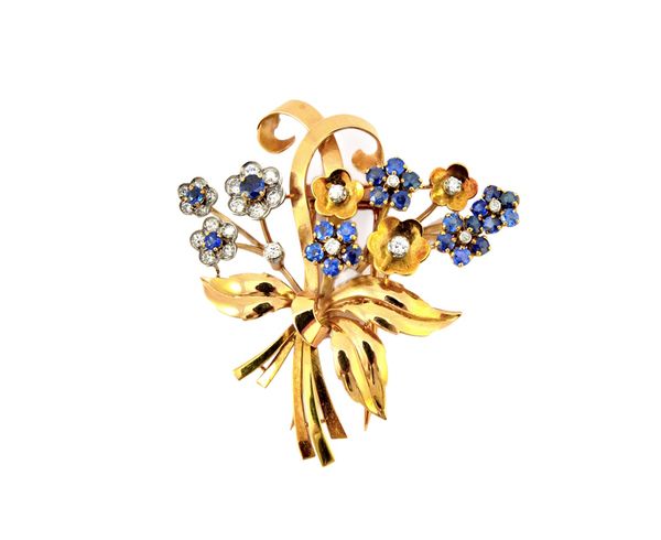 A two colour gold, sapphire and diamond set brooch designed as a tied bouquet of flowers, 5.2cm wide, gross weight 20.6gms.  Illustrated