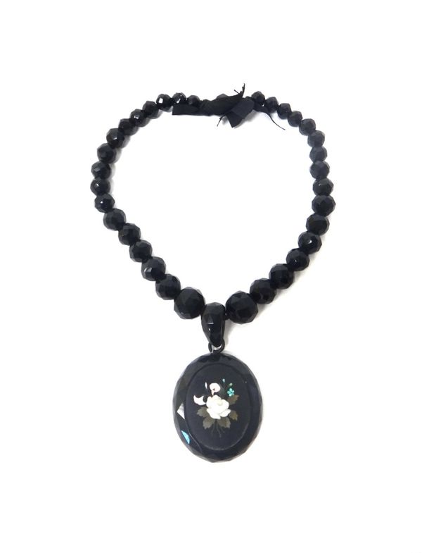 A Victorian oval Florentine pietra dura pendant, designed as a floral spray, fitted to a graduated faceted black glass bead necklace.