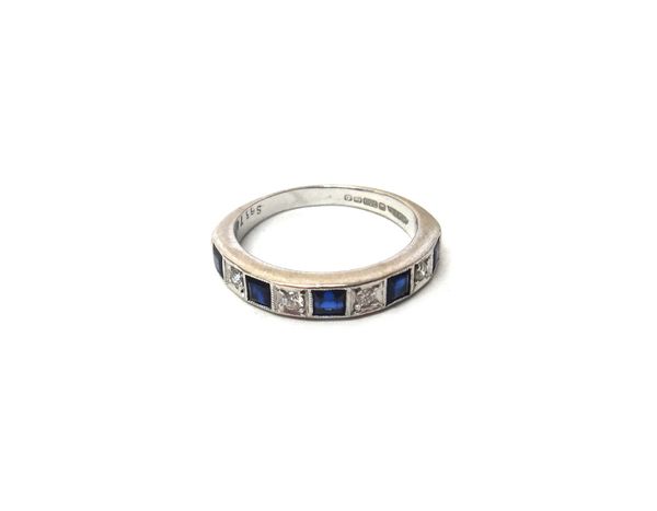 An 18ct white gold, sapphire and diamond set nine stone half hoop ring, mounted with five square cut sapphires, alternating with four circular cut dia