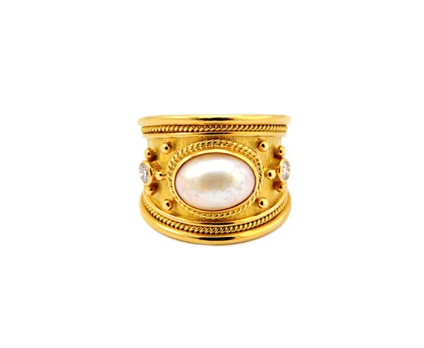 An Elizabeth Gage gold, blister pearl and diamond set ring, mounted with the oval blister pearl at the centre, between two circular cut diamonds, the