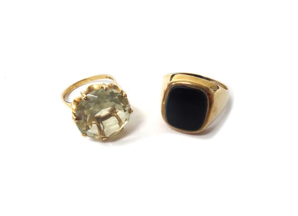 A 9ct gold ring, claw set with a circular cut pale yellow quartz, ring size N and a 9ct gold and black onyx set gentleman's signet ring, ring size W a