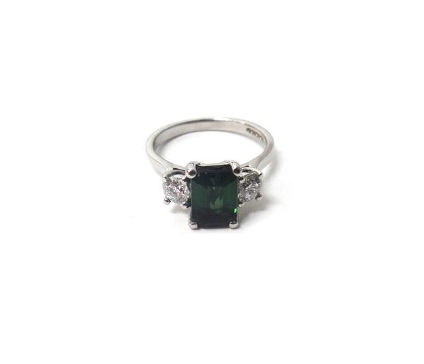 An 18ct white gold, green tourmaline and diamond set three stone ring, claw set with the cut cornered rectangular cut green tourmaline at the centre,