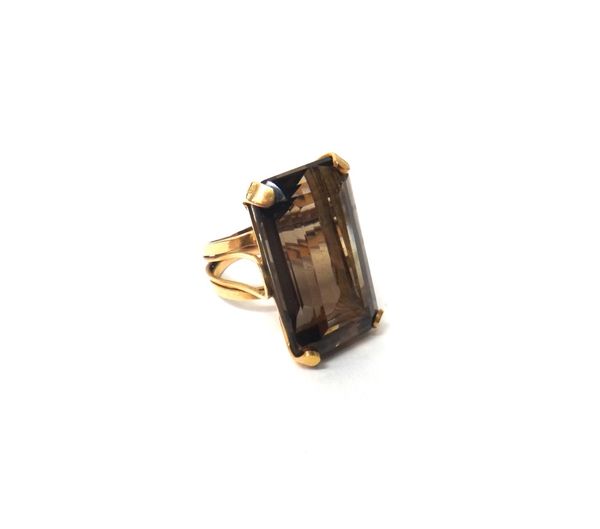 A Middle Eastern gold ring, claw set with a rectangular step cut smoky quartz, ring size H, with a case.