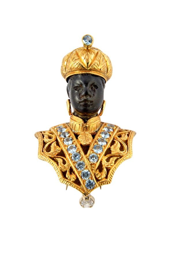 A gold, diamond and pale blue gemstone set brooch, modelled as the bust of a Blackamoor wearing a turban, the drop mounted with a pear shaped diamond,