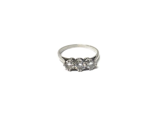 A diamond set three stone ring, claw set with a row of circular cut diamonds and with the principal diamond mounted at the centre, ring size L.