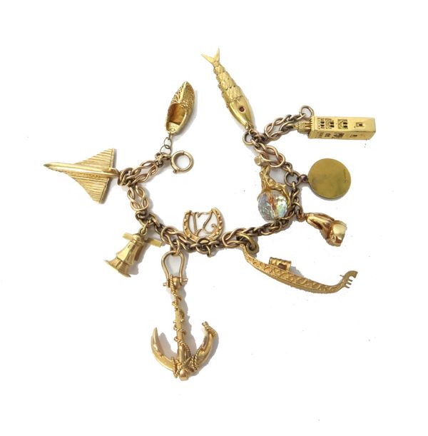 A 9ct gold charm bracelet, fitted with eleven mostly 9ct gold pendants and charms, including; an anchor, a gondola, a windmill and a fish, gross weigh