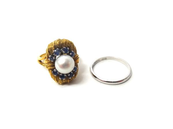 A gold ring, mounted with a cultured pearl at the centre, between two curved rows of four circular cut sapphires, between split shoulders, ring size L