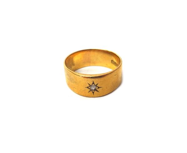 A gentleman's 18ct gold and diamond set single stone band ring, star gypsy set with a cushion shaped diamond, London 1915, ring size V and a half, gro