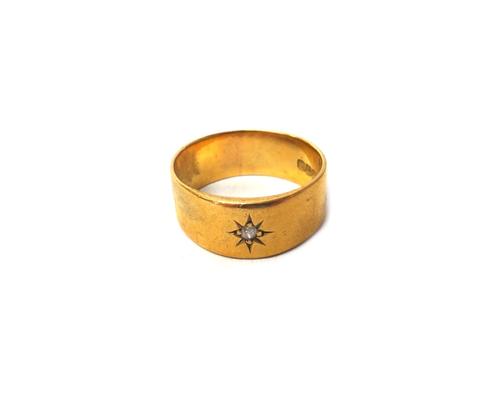 A gentleman's 18ct gold and diamond set single stone band ring, star gypsy set with a cushion shaped diamond, London 1915, ring size V and a half, gro