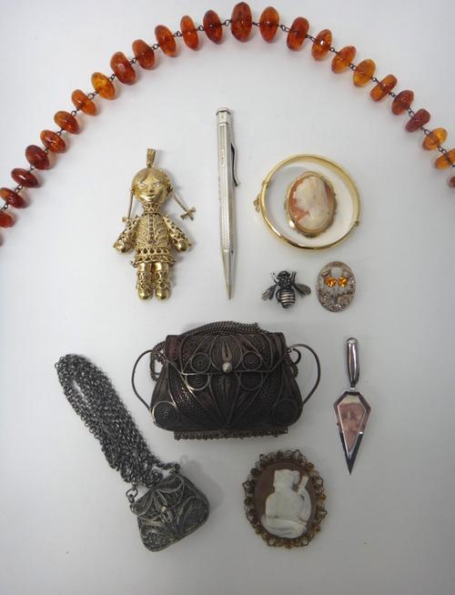 A silver gilt and gem set pendant, designed as a doll, two oval shell cameo brooches, two further silver brooches, a single row necklace of graduated