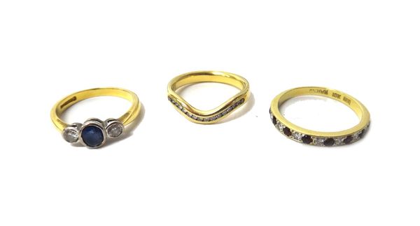 An 18ct gold, sapphire and diamond set three stone ring, mounted with the oval cut sapphire at the centre, between two circular cut diamonds, a gold,