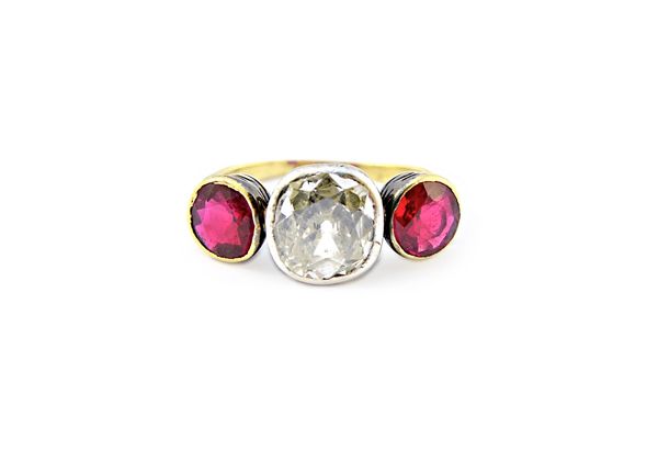 A diamond and synthetic ruby set three stone ring, mounted with the cushion shaped diamond at the centre, size of diamond approx 1.30 cts, between two