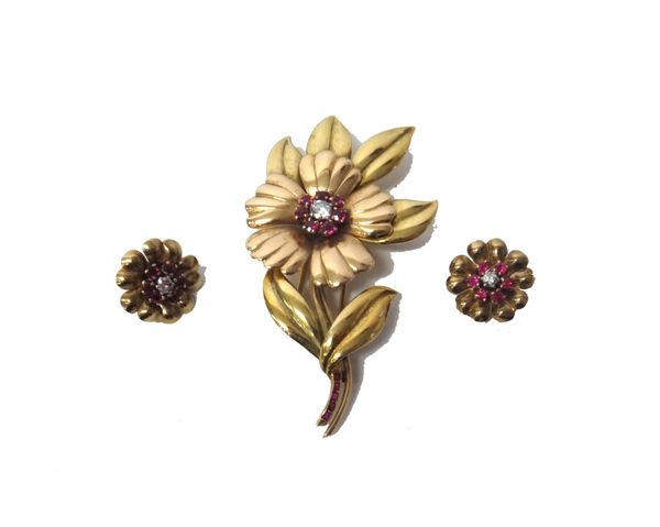 A two colour gold, ruby and diamond set brooch, designed as a flower spray, mounted with the principal circular cut diamond at the centre, in a surrou