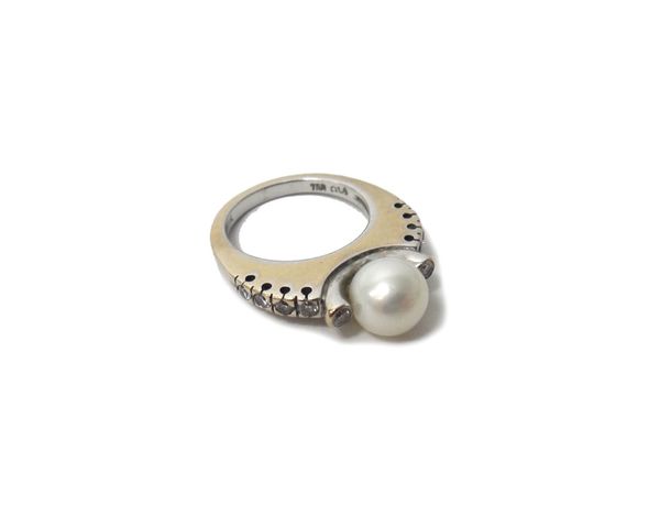 A white gold, diamond and cultured pearl set ring, mounted with a single cultured pearl and the centre, between two collet set circular cut diamonds,