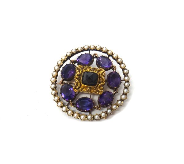 An amethyst and half pearl set brooch, pierced in a circular design, mounted with seven oval cut amethysts, within a border of half pearls.