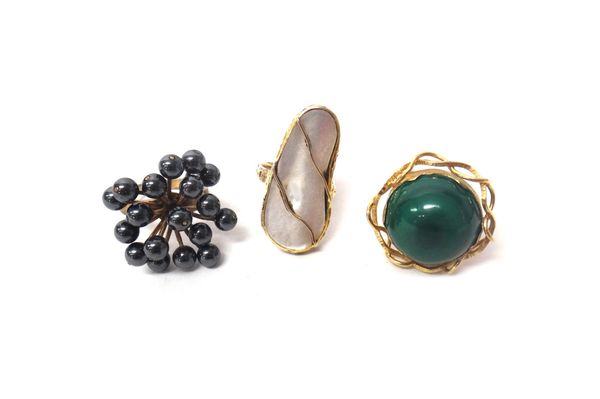 A gold ring mounted with a circular malachite, within an openwork border, a mother of pearl set ring of panel shaped form and a dress ring mounted wit