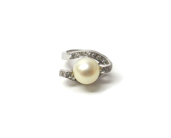 A white gold ring, mounted with a cultured pearl at the centre, between diamond set twist over sides, set with circular cut diamonds, detailed 18 K 75