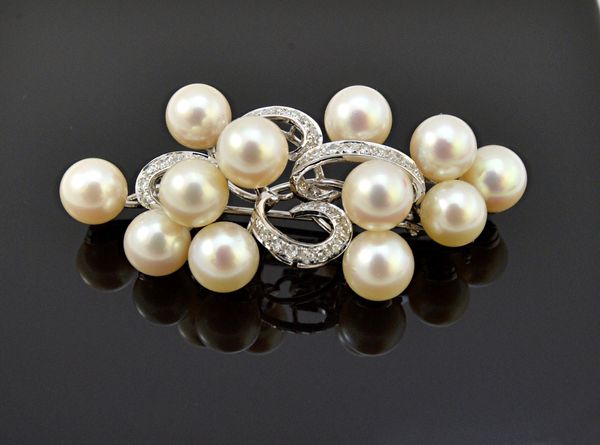 A white gold, cultured pearl and diamond set brooch, in a scroll pierced openwork design, mounted with twelve cultured pearls and otherwise set with c