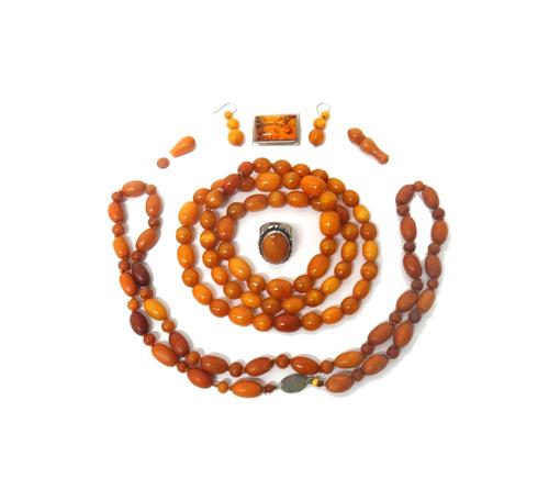 A single row necklace of smaller oval and circular amber beads, a single row necklace of larger reconstituted amber beads, a pair of amber triple bead