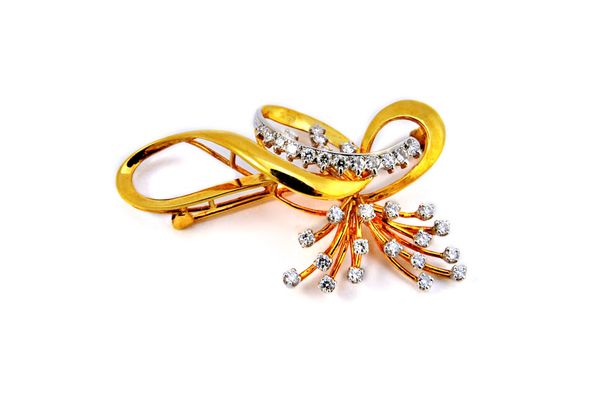 A gold and diamond set brooch, in a wirework spray and interwoven abstract design, mounted with circular cut diamonds, detailed 18 K 750, gross weight