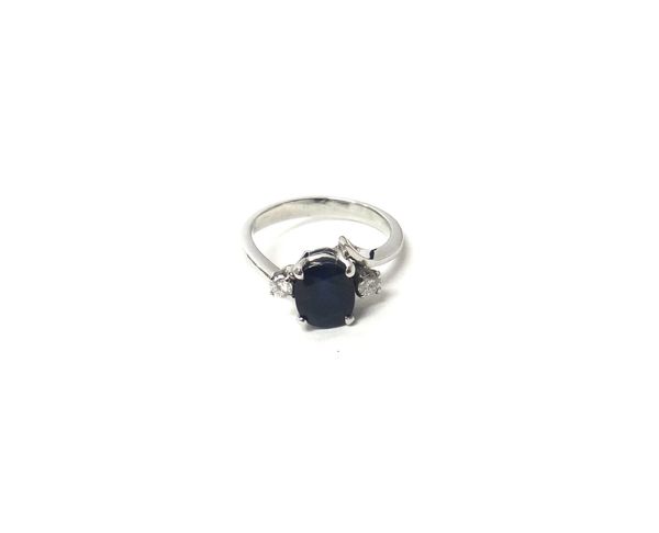 A sapphire and diamond set three stone ring, claw set with the oval cut sapphire at the centre, between two circular cut diamonds, ring size K and a h