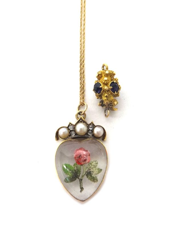 A Victorian gold mounted reverse painted heart shaped intaglio crystal pendant, designed as a floral spray, the surmount set with three half pearls an