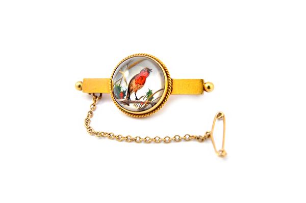 A gold mounted reverse painted intaglio crystal bar brooch, designed as a robin perched on a holly branch, within a cable border, otherwise with bead