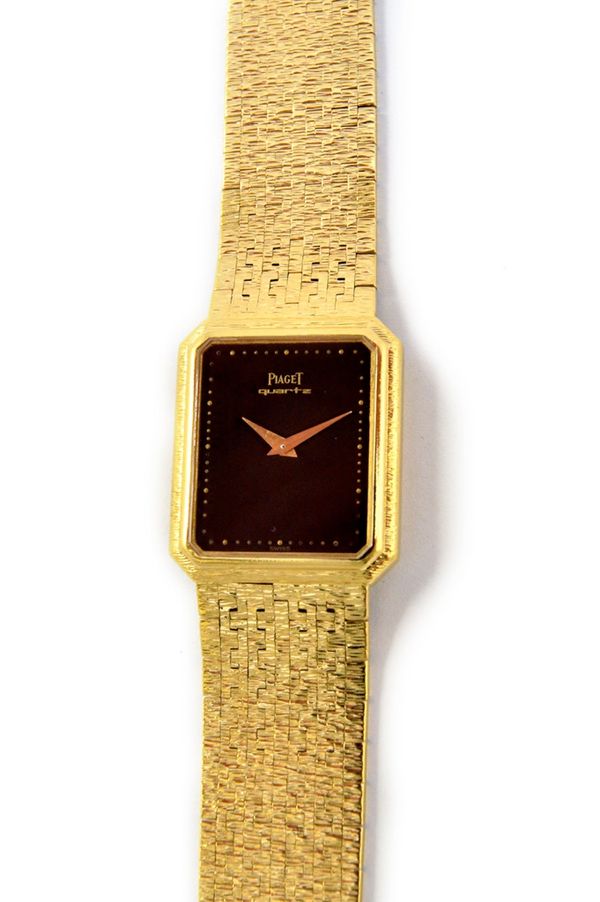 A lady's 18ct gold Piaget quartz rear winding rectangular cased wristwatch, with a signed rectangular black dial, having tapering gilt hands, on a bar