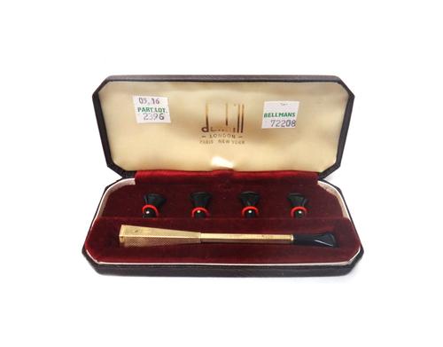 A 9ct gold mounted Dunhill cigarette holder, having engine turned decoration, Birmingham 1962, with four spare mouth pieces, with the original Dunhill
