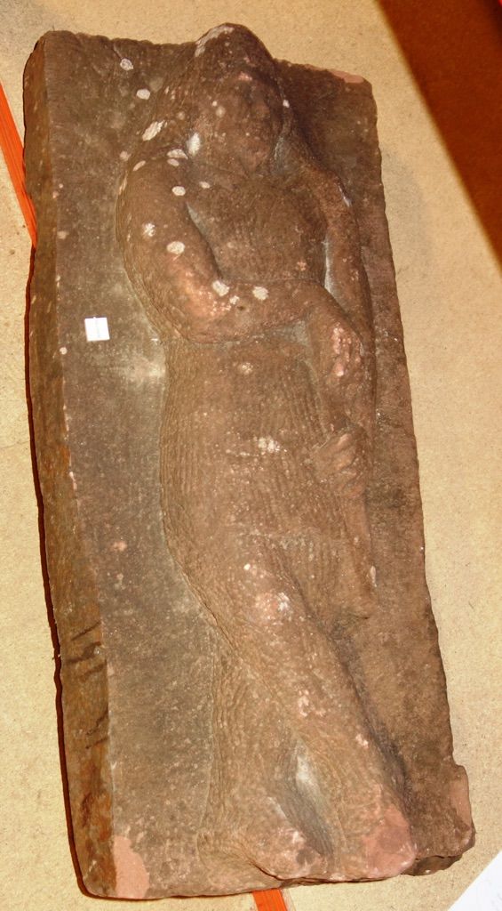 A sandstone carving, relief carved with a figure, 67cm.