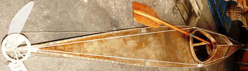A 20th century wooden kayak and a GEES paddle.