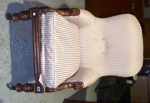 An early 19th century mahogany framed easy armchair with scroll arm finials and turned supports.