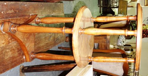 An early 19th century elm circular two tier dumb waiter, on baluster turned supports and triform platform, 35cm wide.
