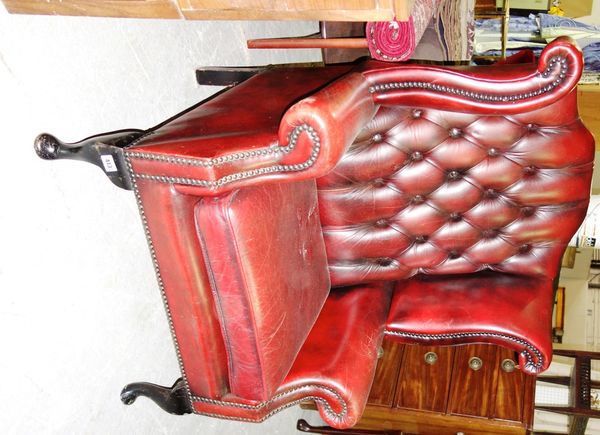 A 20th century red leather wing back armchair.