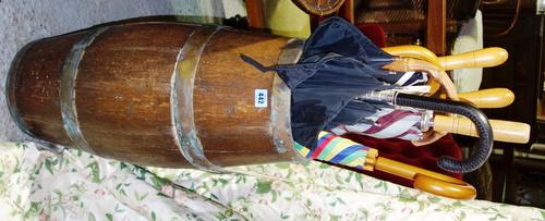 A coopered barrel stick stand and a quantity of umbrellas.
