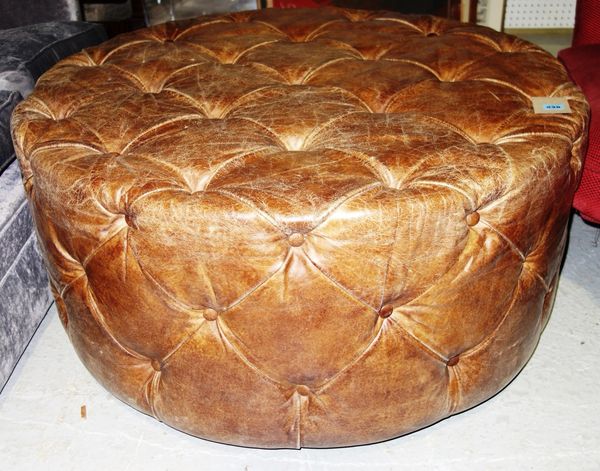 A large brown leather circular stool.