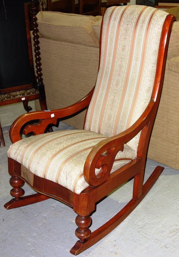A walnut framed Victorian upholstered rocking chair.
