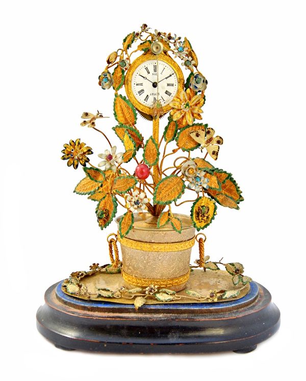 A French novelty brass mantel clock, early 20th century, modelled as a flowering plant and housed under a glass dome, the white enamel dial detailed '