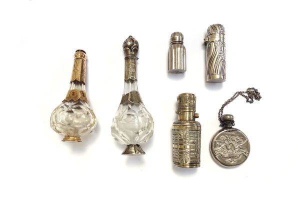 An embossed silver scent bottle, hallmarked Birmingham 1897, 6cm, together with two similar glass and metal mounted scent bottles, each raised on a ci