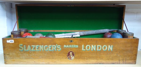 A Slazengers croquet set, circa 1905, comprising four mallets, coloured balls and iron hoops with scoring markers, in an oak box with gilt decoration,