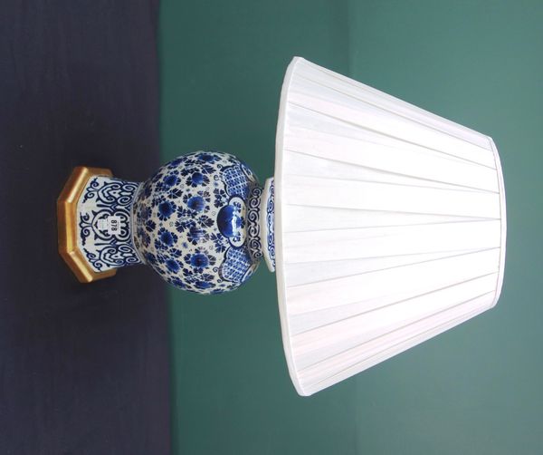 A Dutch Delft style pottery vase and cover, 20th century, adapted to a table lamp with a pleated shade, 44cm high.