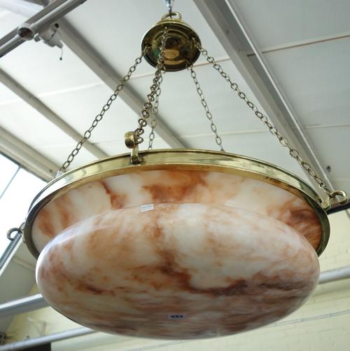 An Edwardian alabaster and cast brass ceiling light, circa 1910, with a broad dished base suspended by five linked chains, 65cm dia, 94cm high.